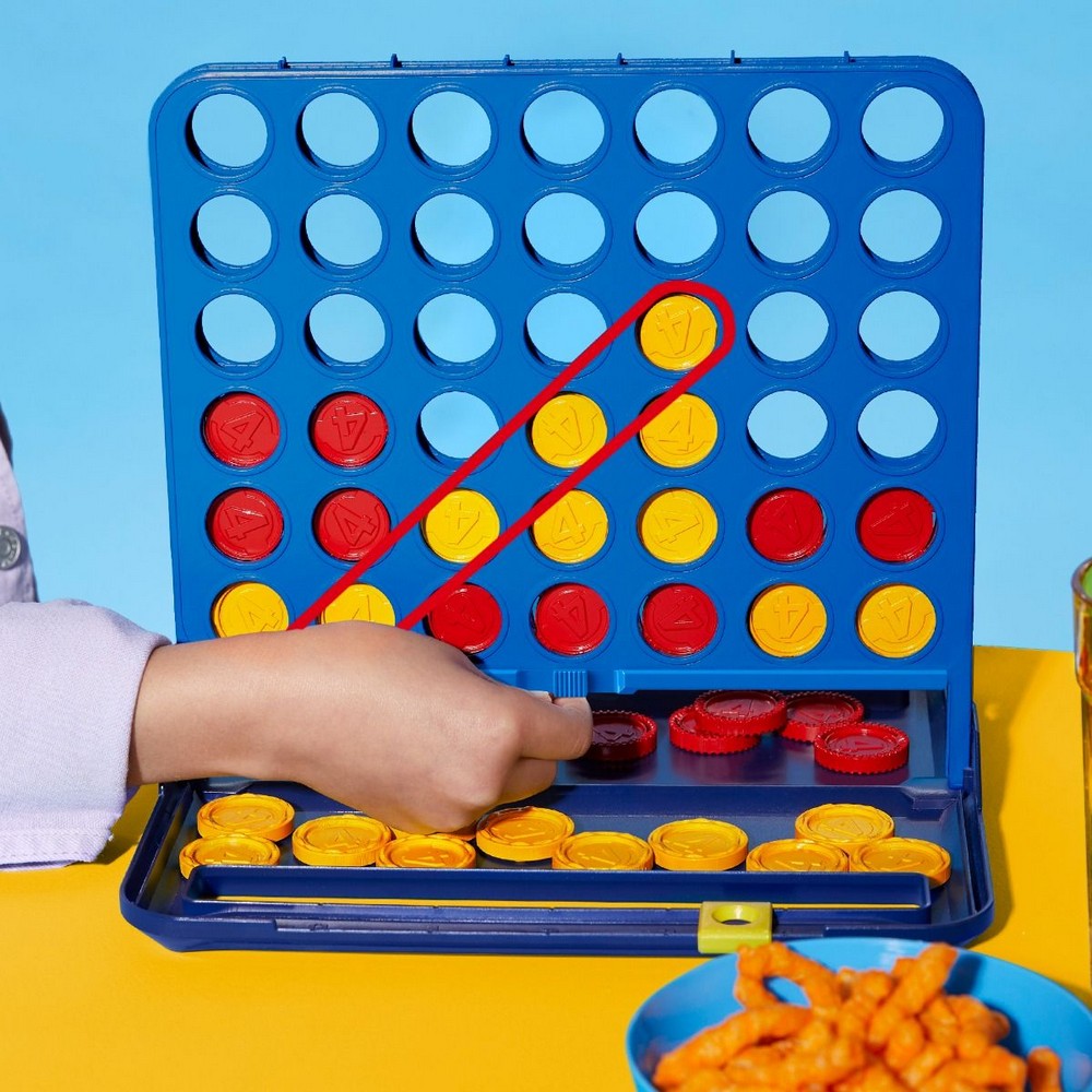 Child playing with a connect four game on a blue background