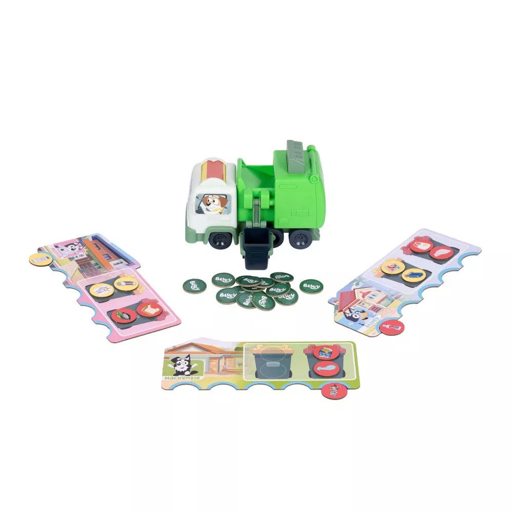 A children's toy garbage truck game set on a white background, featuring a green and white truck, several colorful game boards, and green circular tokens.