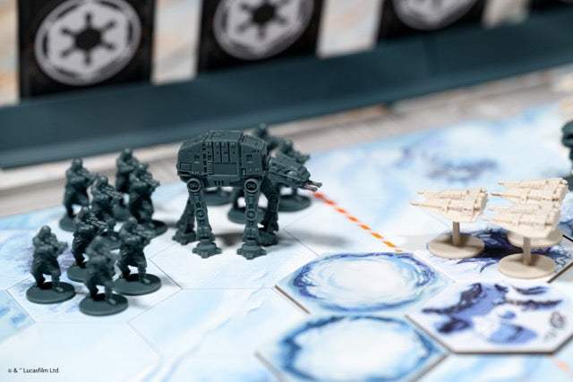 Board game setup with miniature figures and a large vehicle on a map