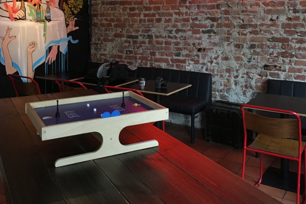 Indoor gaming setup with a small table-top game against a brick wall.