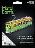 Metal Earth Melbourne W-Class Tram metal model kit packaging on a black background, showing a green and yellow tram illustration, product text, and two small black tools at the bottom.
