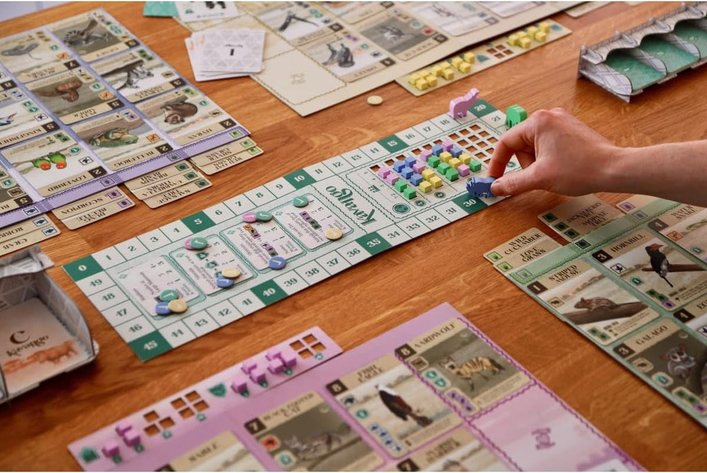 Board game being played on a wooden table with various game pieces and cards.