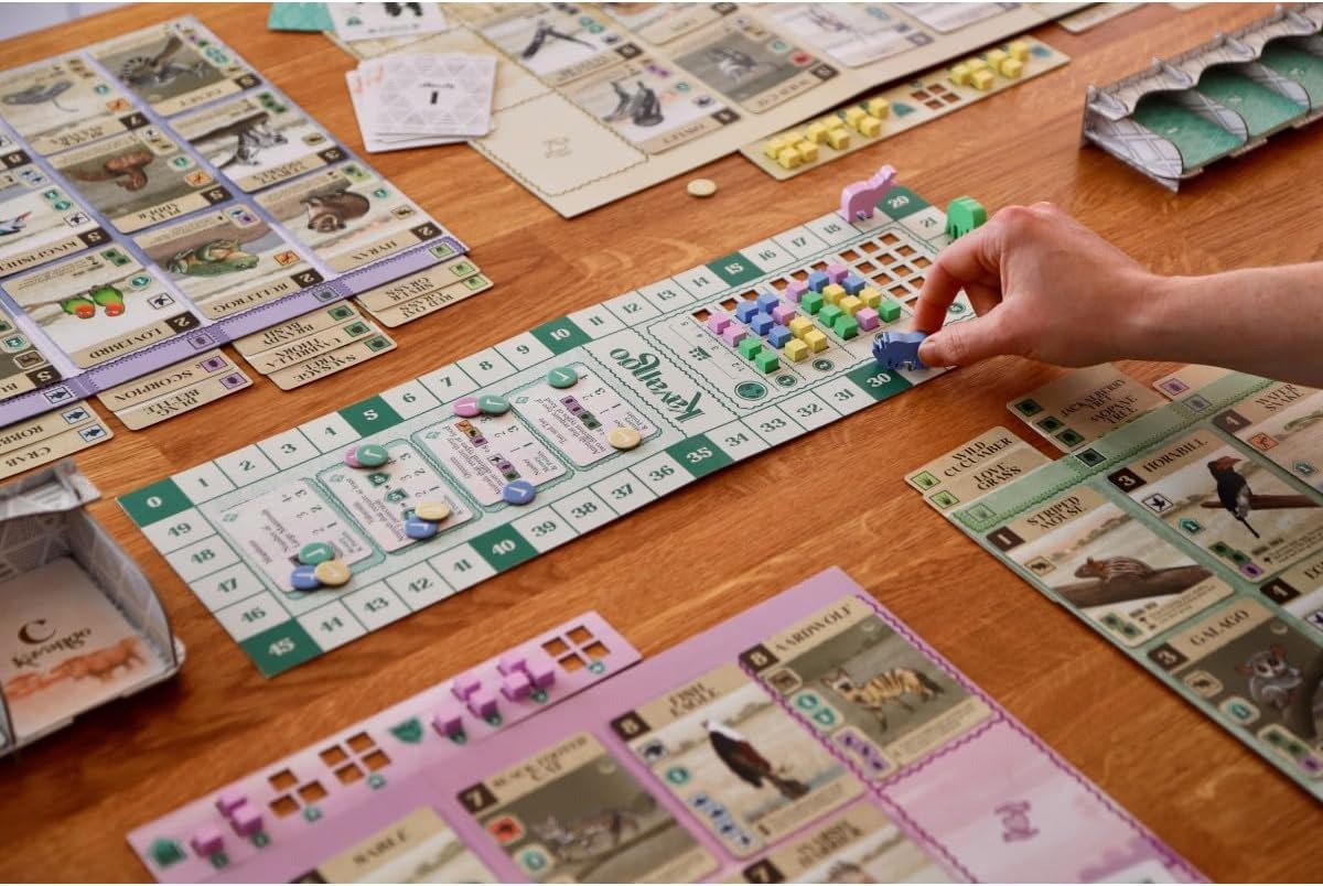 Board game being played on a wooden table with various game pieces and cards.