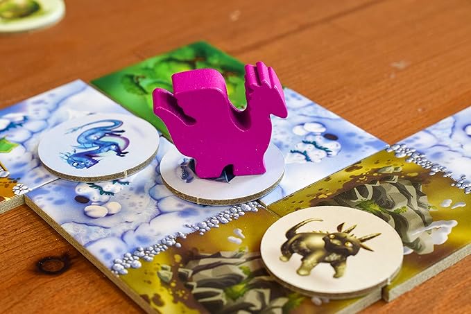 Board game with animal-themed cards and a pink elephant-shaped piece on a wooden surface