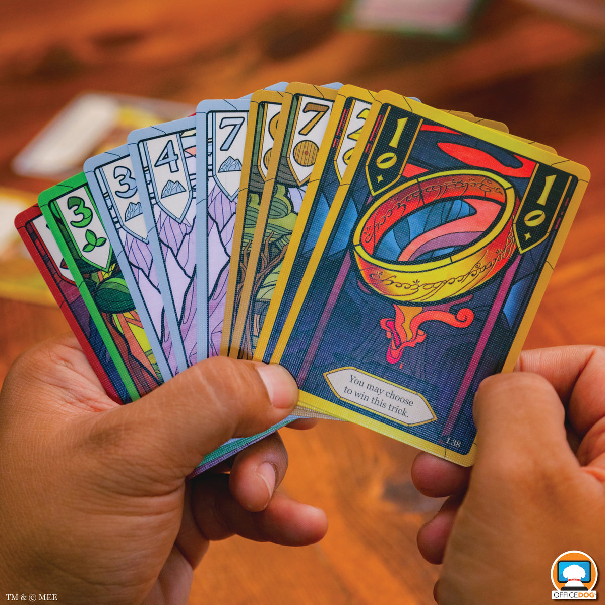 Colorful playing cards held by hands on a wooden surface
