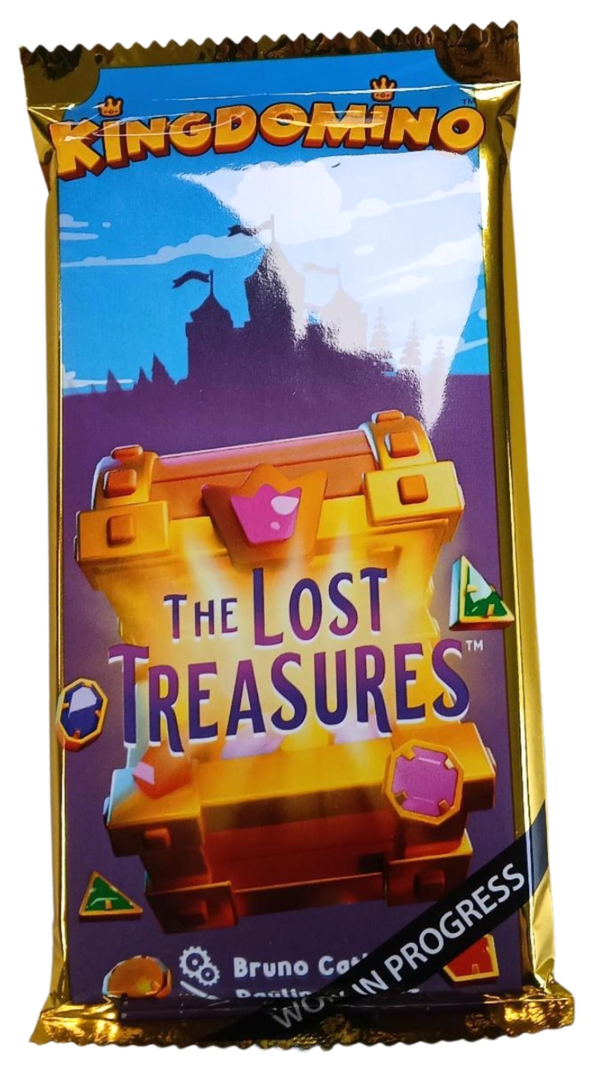 Kingdomino 'The Lost Treasures' card pack in gold foil packaging with a colorful illustration of a treasure chest and castle.