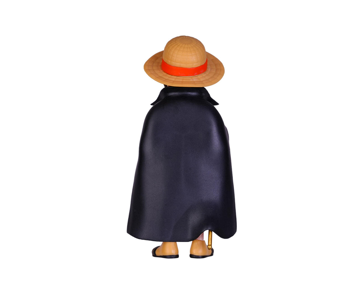 A back view of a character figurine wearing a straw hat with a red band, a dark navy blue cape, and tan shoes, isolated on a white background.