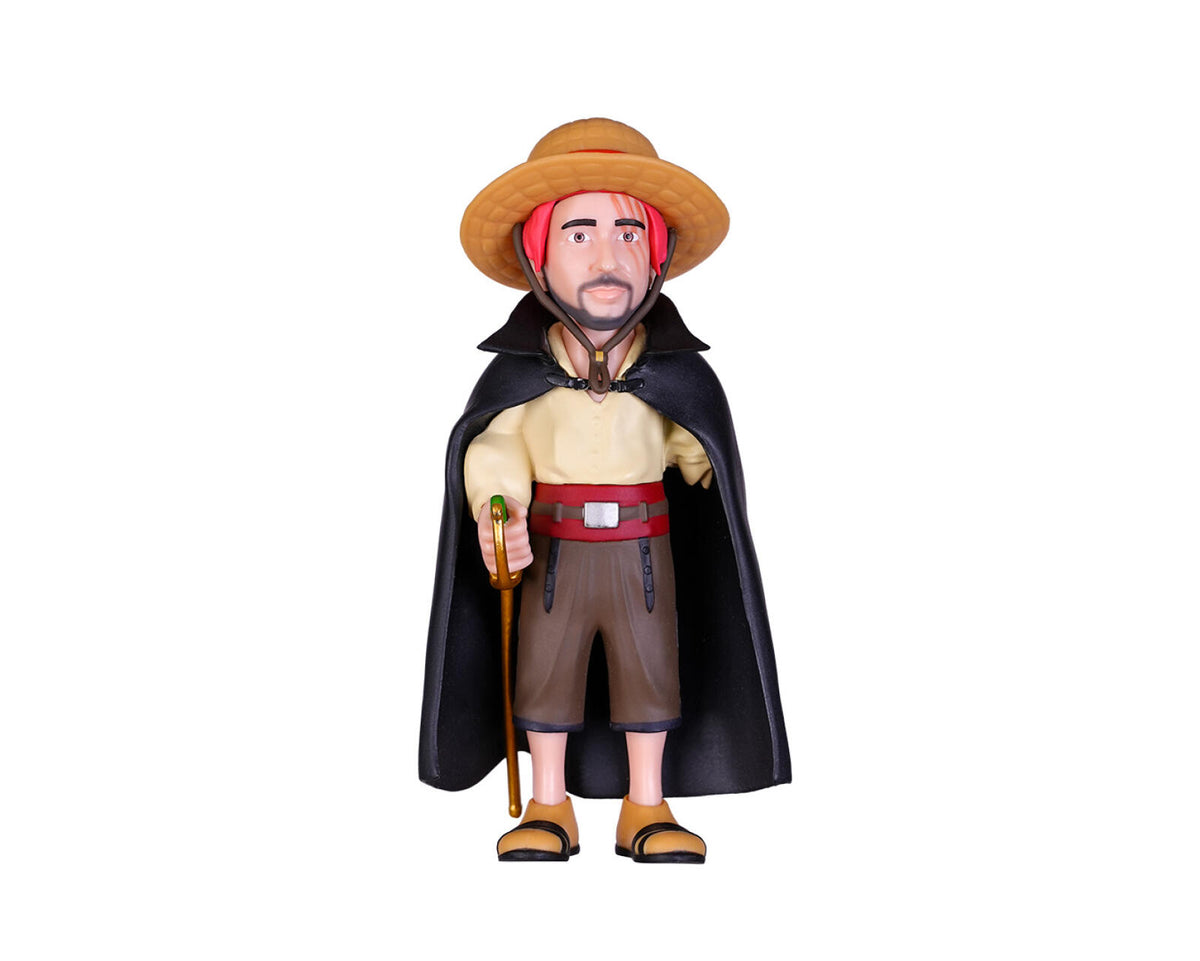 A stylized collectible figurine of a man dressed as a pirate or explorer, wearing a tan hat, a black cape, a beige shirt, brown shorts, and sandals, holding a staff against a plain white background.